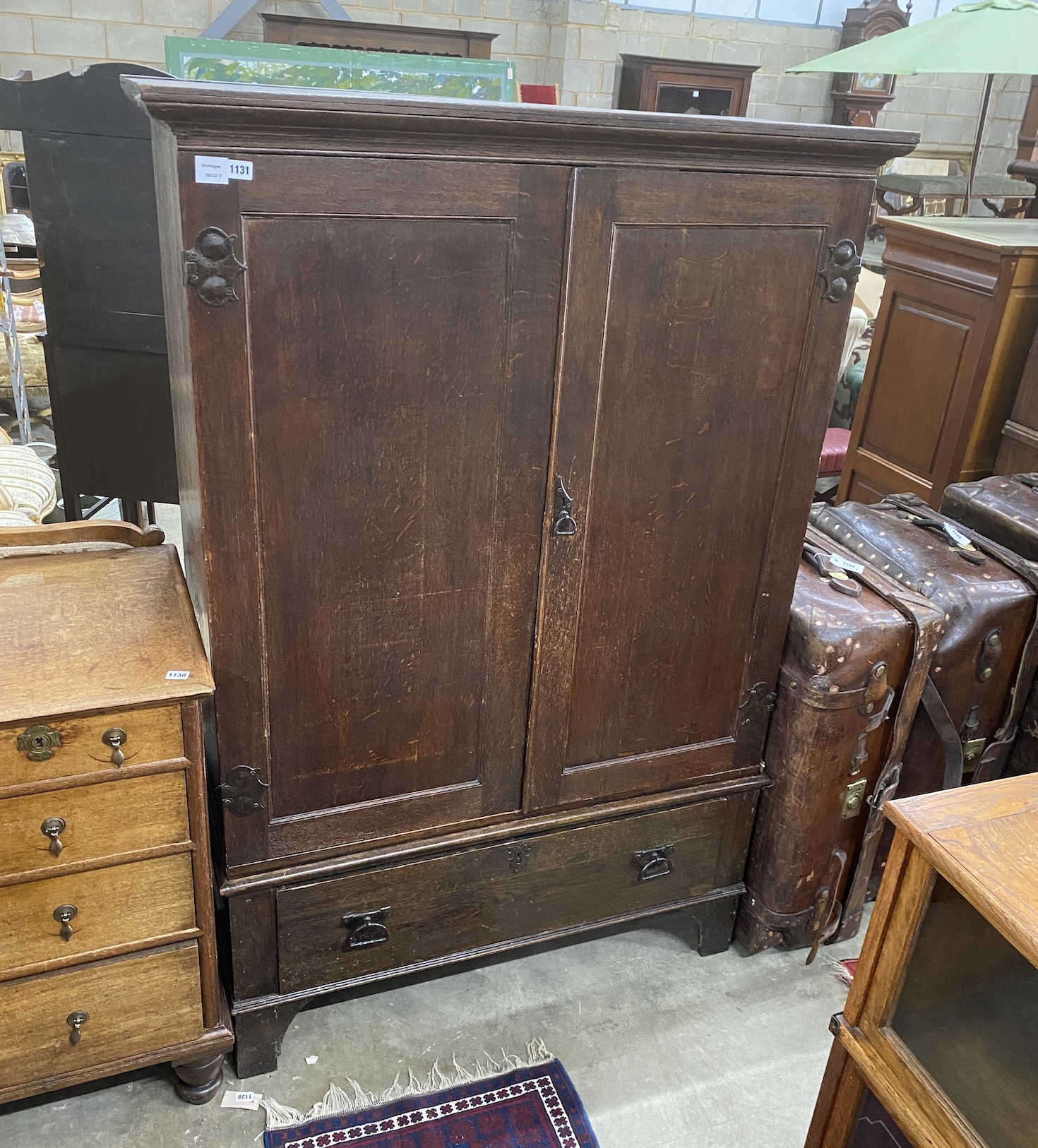 A late 18th century oak hanging cupboard, with later Art Nouveau hammered copper hinges, width 116cm, depth 50cm, height 173cm